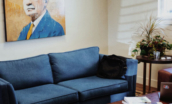 Spazio ufficio con un ritratto di B. H. Roberts, un divano blu e tavoli con vari oggetti.