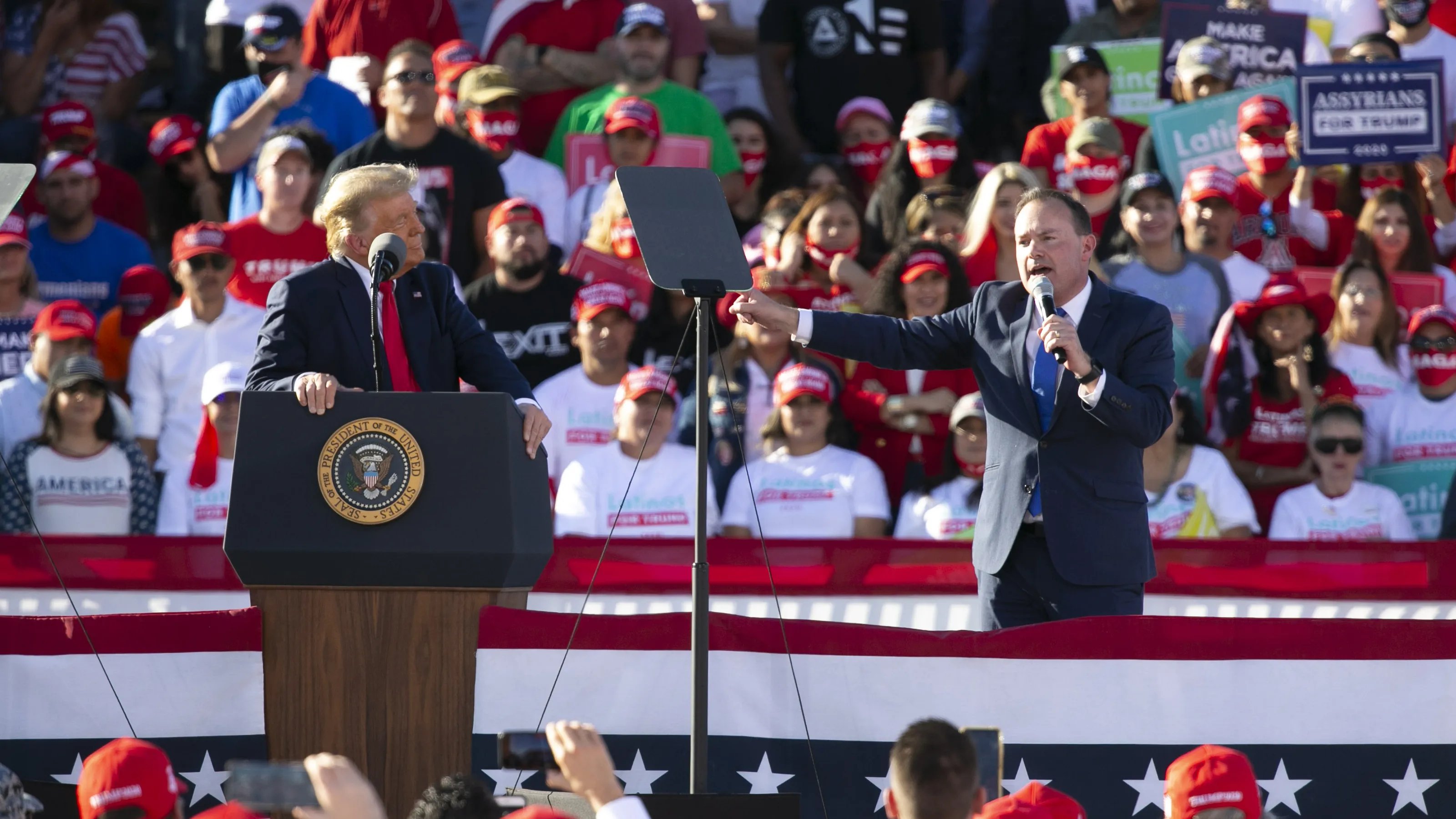 Um comício republicano do GOP em 2020, com Donald Trump no púlpito à esquerda, enquanto Mile Lee faz um discurso em que compara Trump ao Capitão Morôni do Livro de Mórmon.
