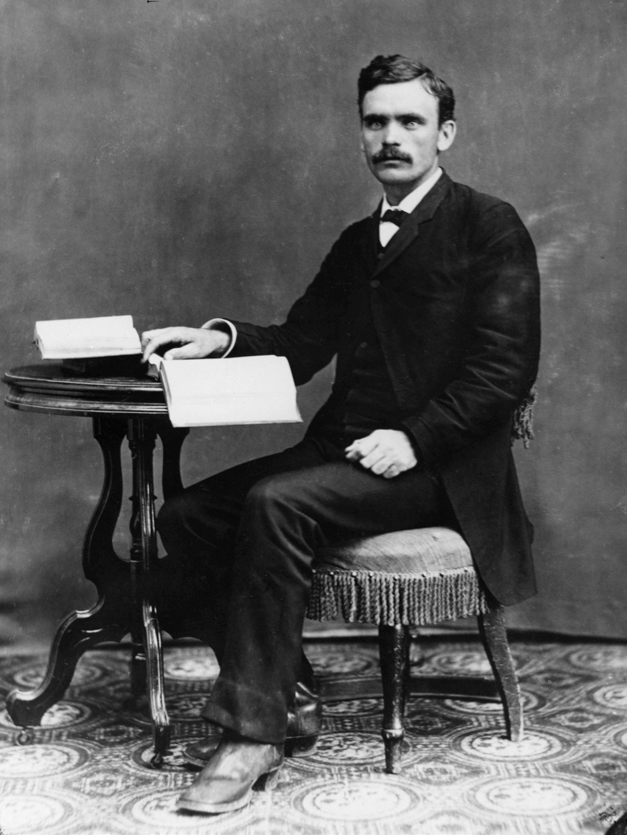 Un retrato fotográfico de Brigham Henry (B. H.) Roberts sentado estudiando algunos libros en algún momento a finales del siglo XIX.