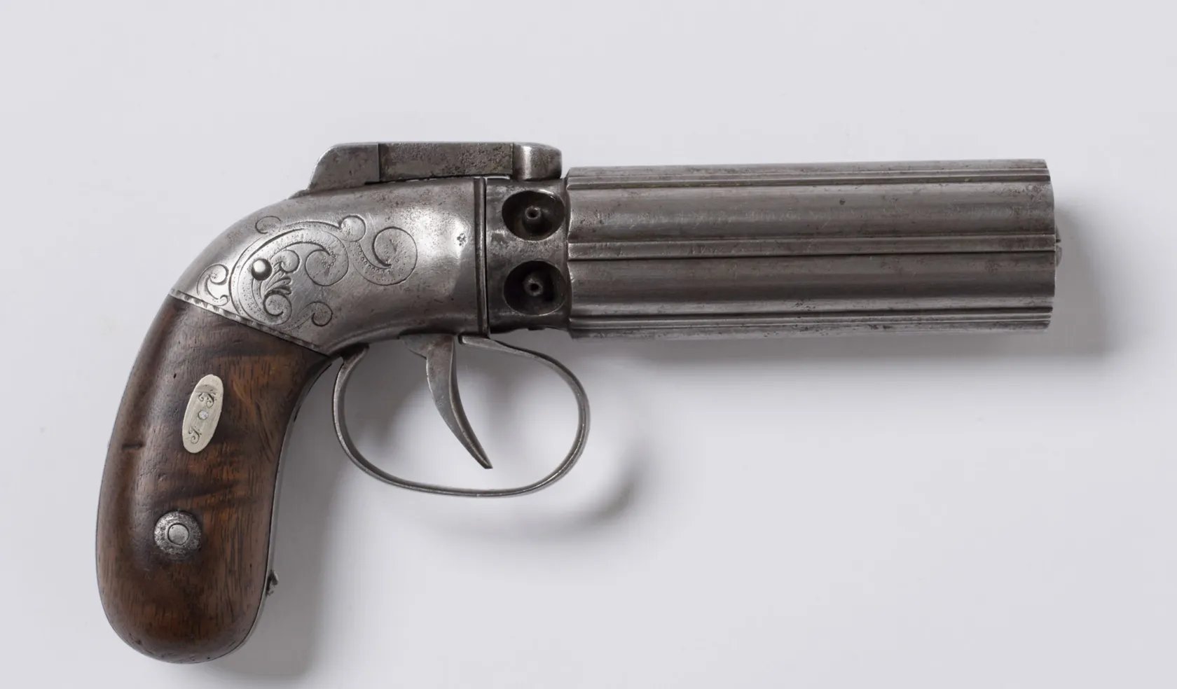 Imagem de uma pistola pepperbox de prata gravada com cabo de madeira que foi usada por José Smith quando ele foi atacado na Cadeia de Carthage, Illinois, em um fundo branco.