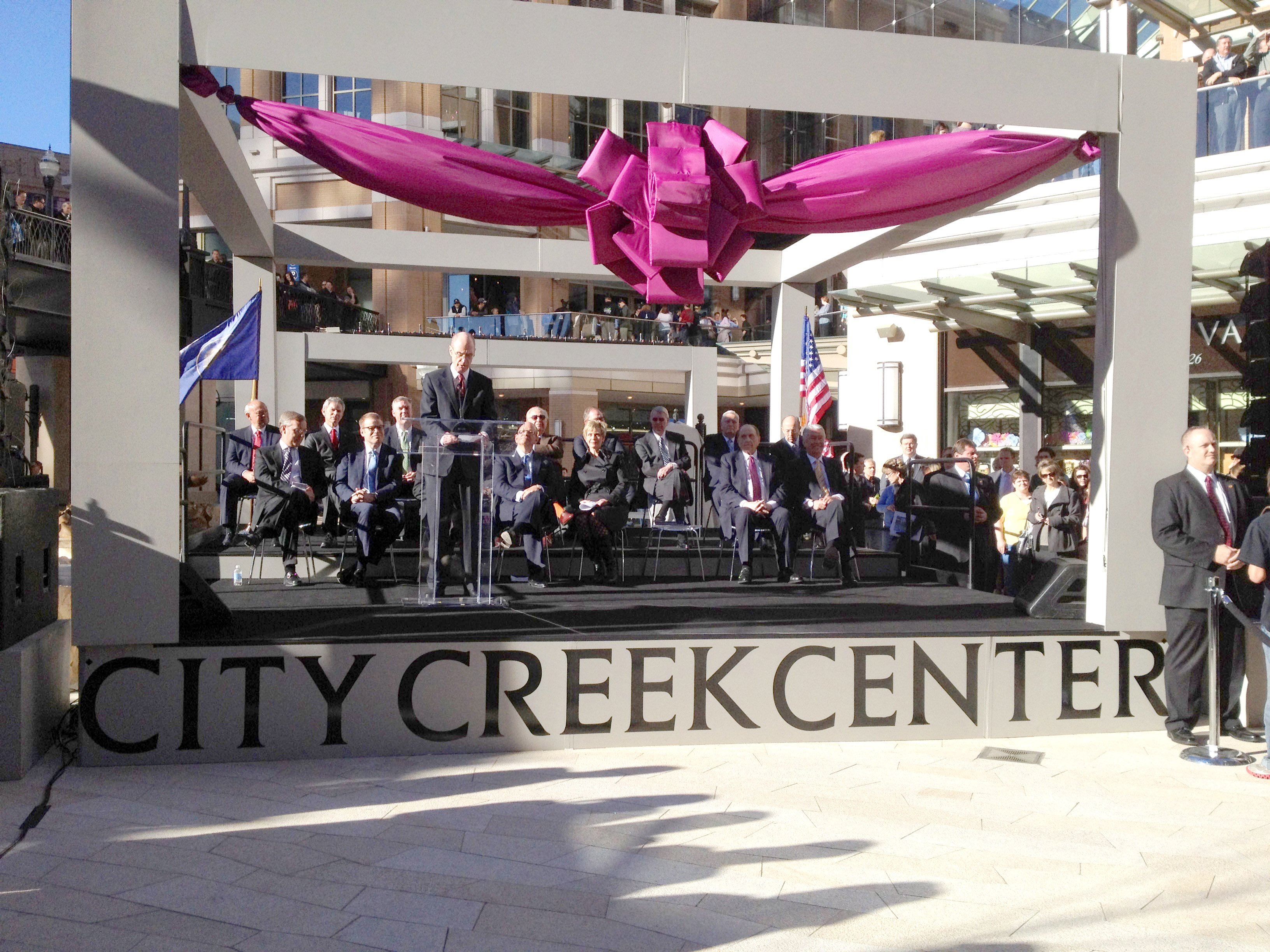 Präsident Henry B. Eyring spricht bei der feierlichen Eröffnung der City Creek Mall in Salt Lake City am 22. März 2012, während Präsident Thomas S. Monson und Präsident Dieter F. Uchtdorf im Publikum sitzen.